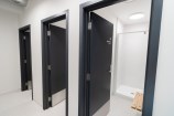 Three separate shower blocks with black doors.
