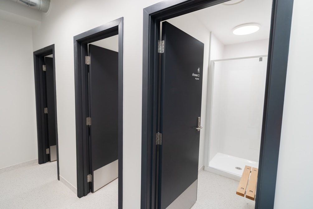 Three separate shower blocks with black doors.