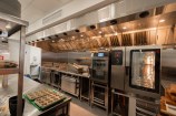 Commercial kitchen with a large oven in the background.