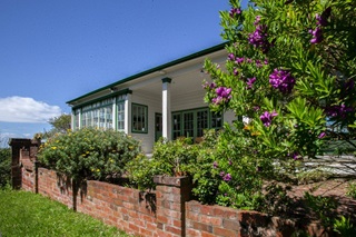 Truby King Park house with a brick fence out front.