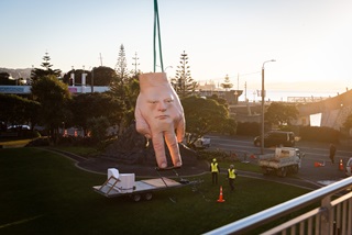 Wellington’s iconic hand-face sculpture, Quasi, being lifted by ropes off the roof of City Gallery Wellington. 