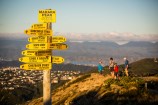 Signs on top of Makara Peak with people on bikes behind it.