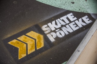 Spray paint on the ground with writing that says We Skate Poneke.