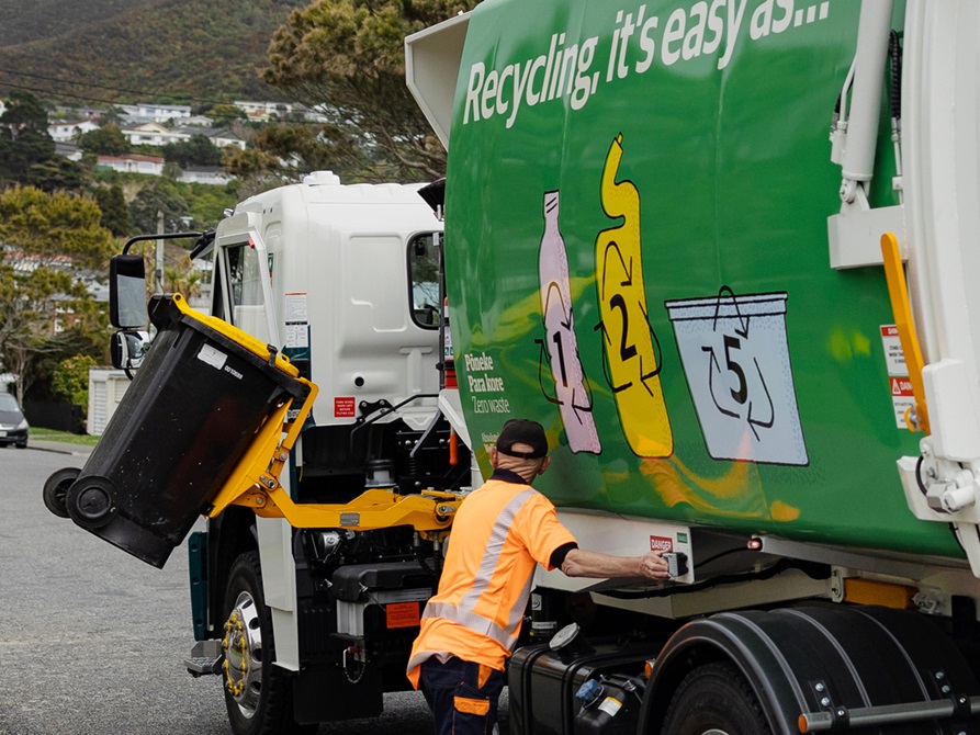 Rubbish truck with a worker emptying a bin.