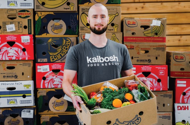 Kaibosh Wellington volunteer Daniel with box of food for recipients.