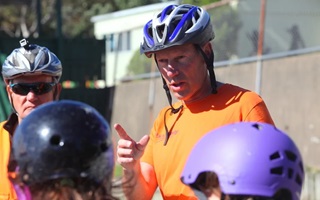 Image of Patrick morgan in high vis vest and a helmet educating a group of children