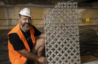 a contractor posing next to a pressed metal sheet 