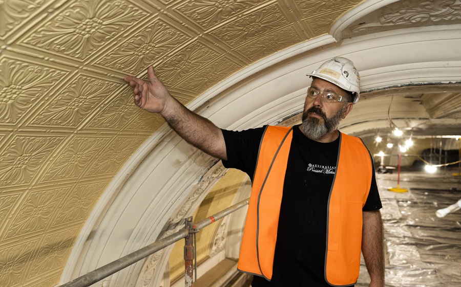 Andrew, pressed metal contractor, pointing at a heritage tile