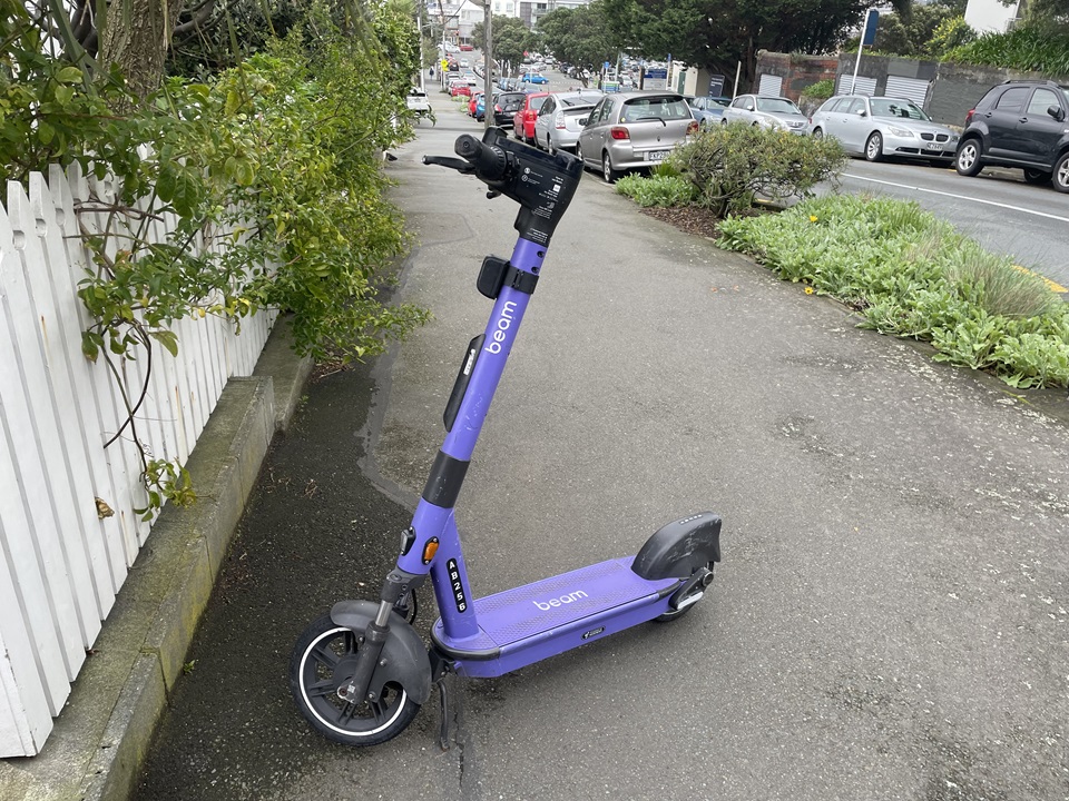 Beam scooter parked on pavement.