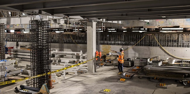 The basement of Te Whare Whakarauiki with two people standing in the construction wearing high vis vests.