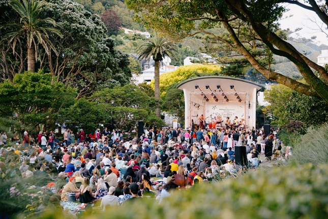 Crowd of people gathered infront of a stage watching Gardens Magic.
