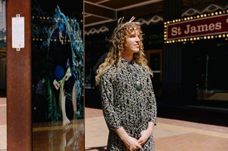 A person standing infront of a lightbox on Courtenay Place.