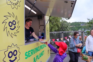 Person reaching up to grab a FillGood cup from a truck.