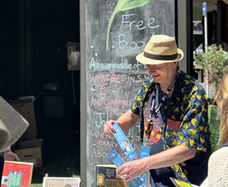 Man in a colourful shirt wearing a fedora.
