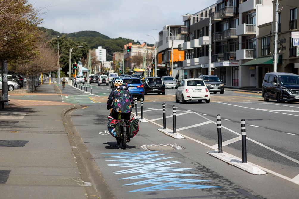Person on a bike going down Cambridge Terrace with cars and buildings in the distance.