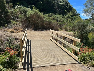 New bridge built over the top of a stream on the side of a hill.