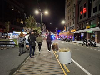 A group of people walking down Dixon Street.