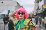 Person wearing a pink wig and dressed up in a fun and vibrant costume.