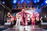 A group of performers dressed in pink on a stage.