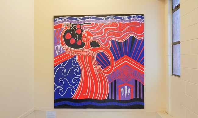 Brightly coloured mural hanging on a wall.