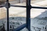 Bus shelter in the middle of an urban street with archival images on it.