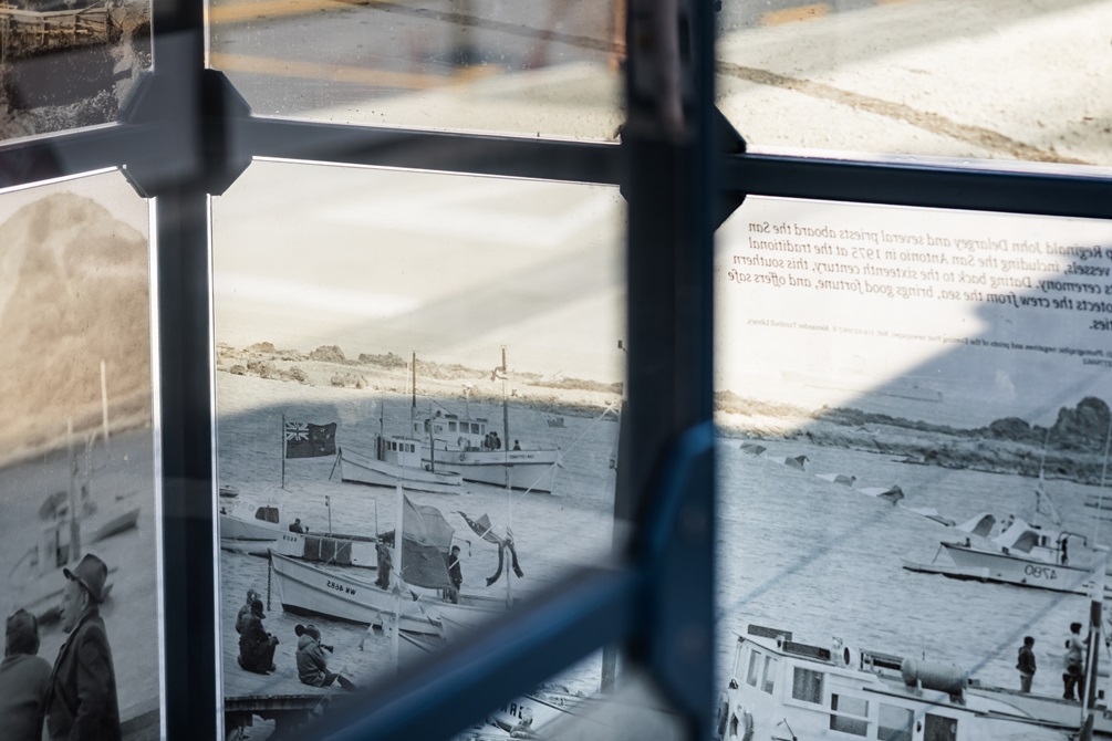 Bus shelter in the middle of an urban street with archival images on it.