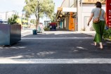 Quotes etched into the pavement with a person walking over the top of them.