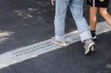 Quotes etched into the pavement with two people walking over the top of them.