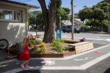Island bay library with stencils on the footpath and a young girl running along it.
