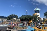Playground with play mats and a slide and swing on the waterfront.