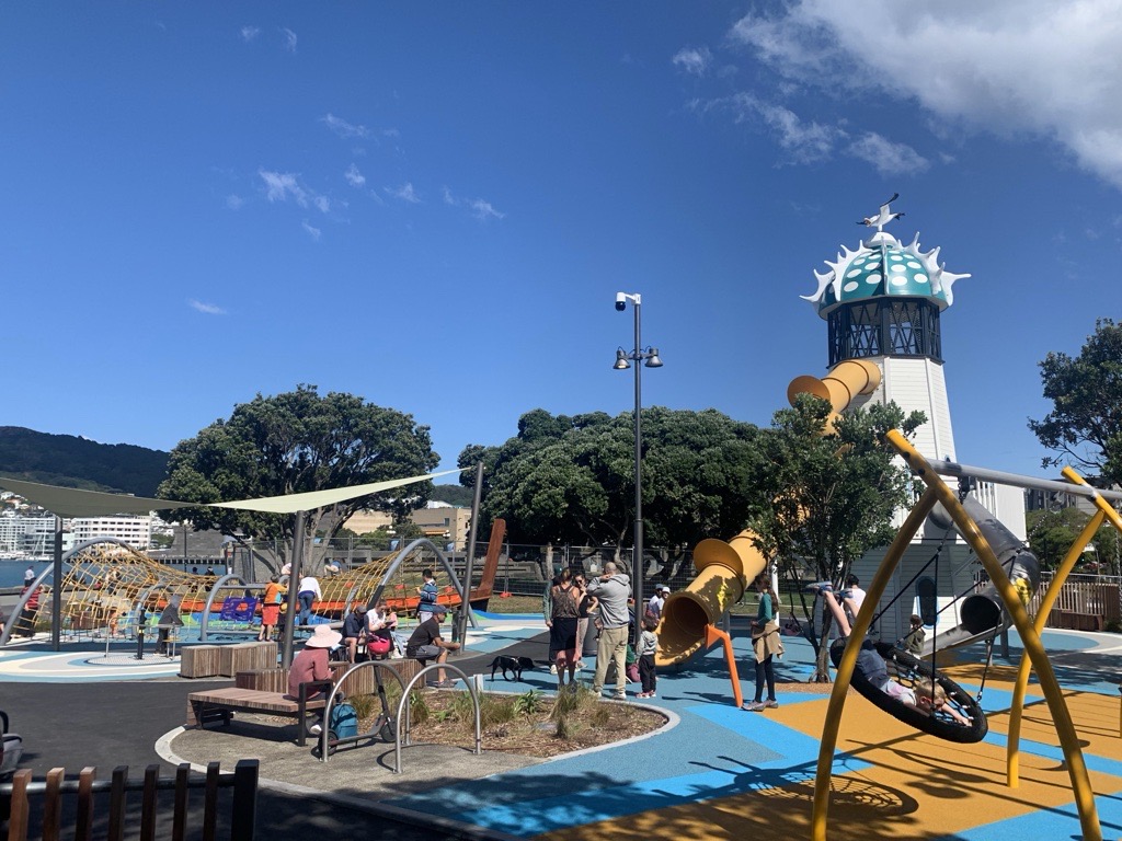 Playground with play mats and a slide and swing on the waterfront.