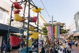 Bucket fountain with people in the background walking down the street.