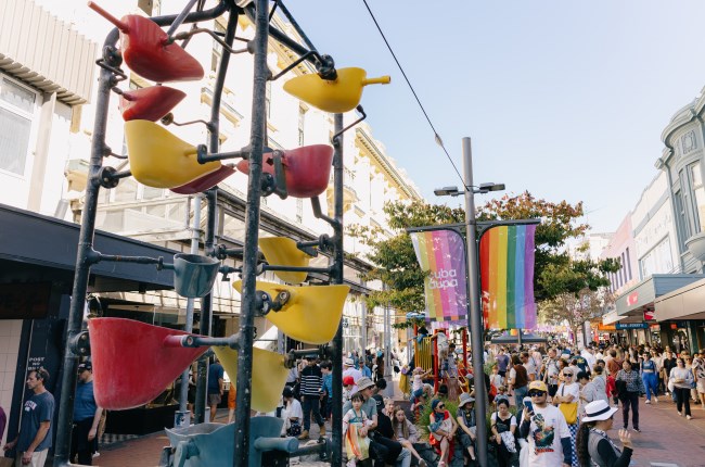 Bucket fountain with people in the background walking down the street.