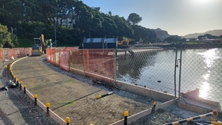 A sandy beach with construction set up around it.