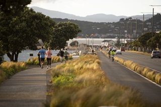 A footpath with people running down it next to a cycle lane with cyclists riding down it.
