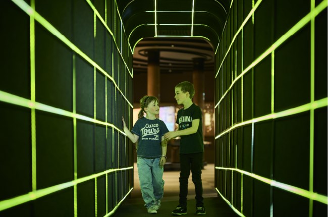 Young people walking through sci fi tunnel at Space Place.