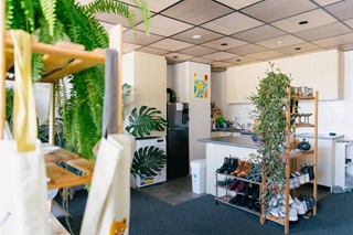 Kitchen area with surrounding shelves full of trinkets and shoes.