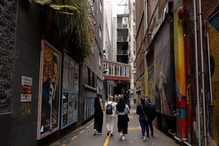 Group of people walking down a colourful alleyway.