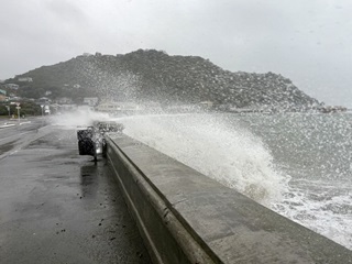Dramatic weather along coast in Island Bay with big waves crashing onto pathways.