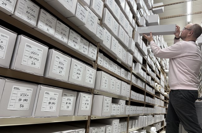 A person pulling out a box from the archives.
