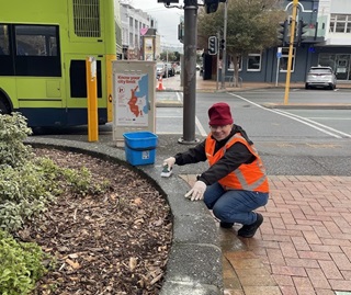 Person in high vis scrubbing on the side of the road.