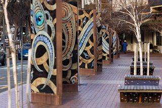 Row of artwork in a light box exhibition.