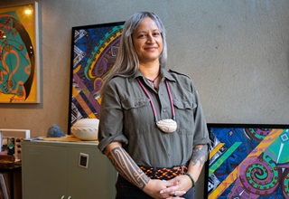 Jaime Berry sitting in front of an artwork.