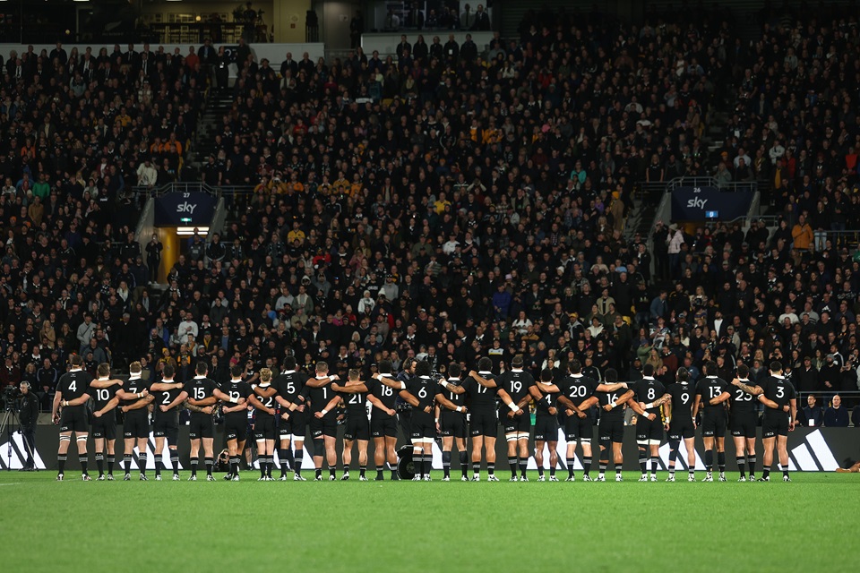 All Blacks face the crowd from the field with arms linked ahead of match.