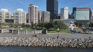 Frank Kitts rock revetment project finished with waterfront promenade and buildings in background.