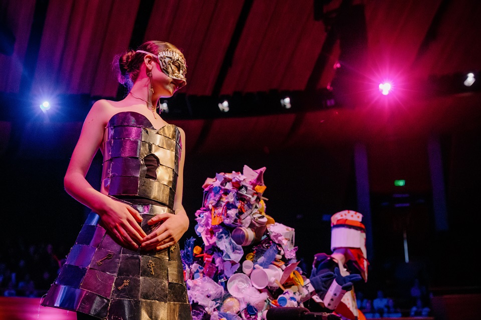 Artsplash wearable arts participants on stage in outfits with bright lights.