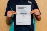 A kid holding their drawing