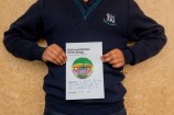 A kid holding their drawing