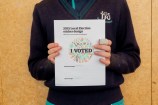 A kid holding their drawing
