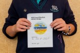 A kid holding their drawing